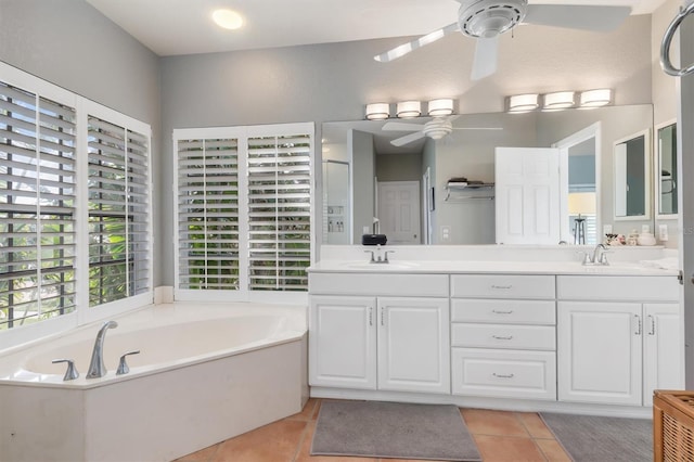 bathroom with ceiling fan, a tub to relax in, vanity, and tile patterned flooring