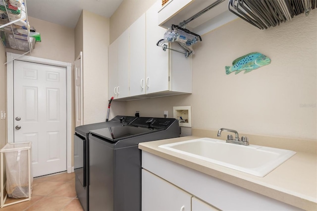 washroom featuring sink, cabinets, light tile patterned floors, and washing machine and clothes dryer