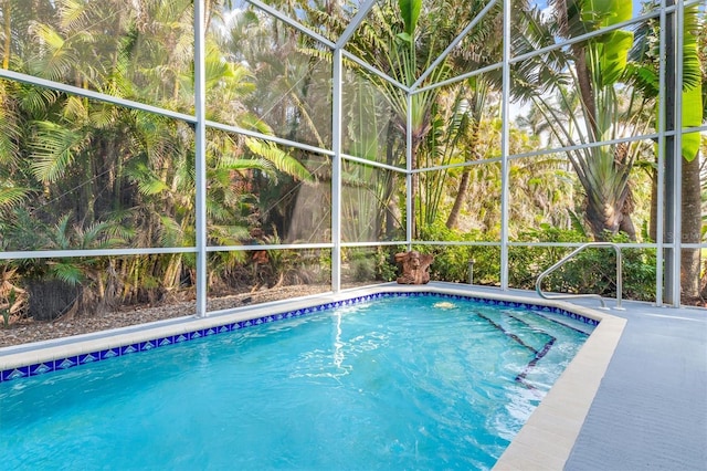 view of pool featuring glass enclosure and a patio area