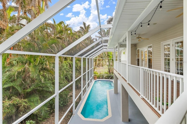 view of swimming pool with ceiling fan, french doors, and a lanai