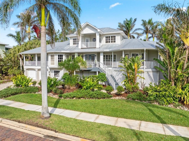 view of front of property with a garage, a front lawn, and a balcony