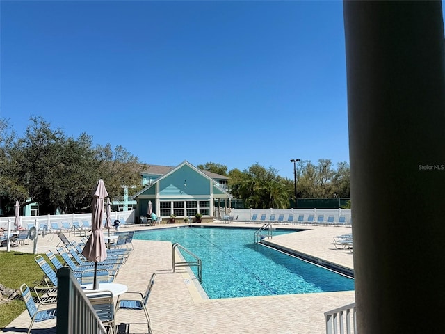 community pool featuring a patio and fence