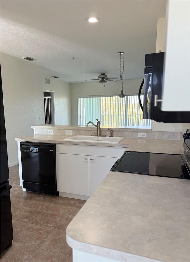 kitchen with electric range, dishwasher, light countertops, white cabinetry, and a sink