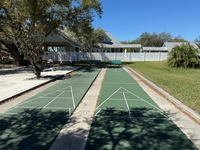 view of home's community with shuffleboard, a lawn, and fence