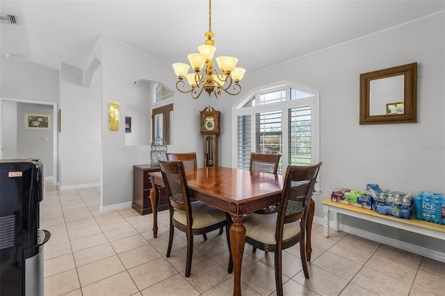 tiled dining area featuring an inviting chandelier and vaulted ceiling