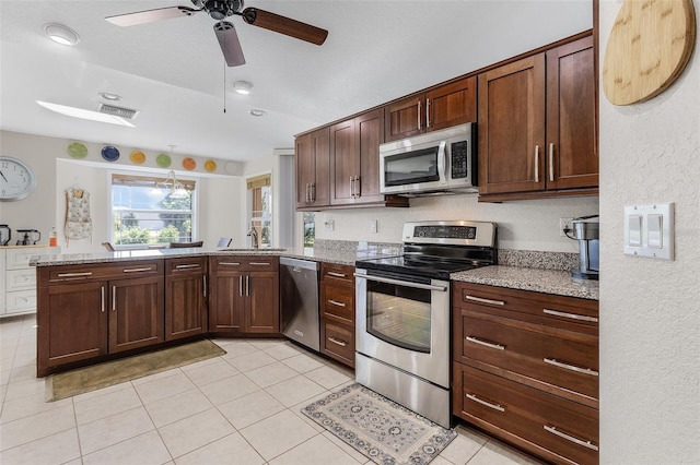 kitchen with ceiling fan, appliances with stainless steel finishes, light stone counters, and sink