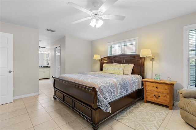 tiled bedroom with ensuite bath, multiple windows, and ceiling fan