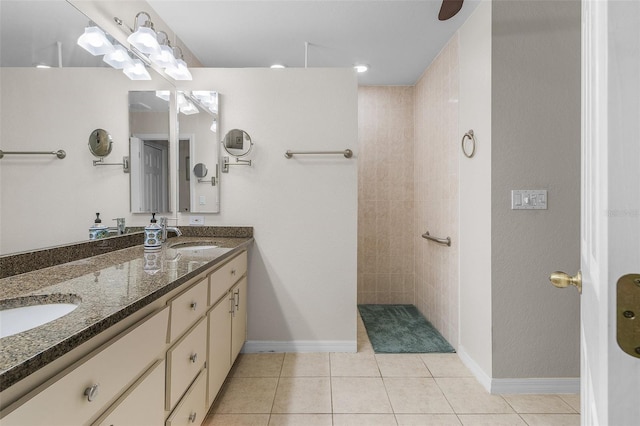 bathroom with tile patterned flooring, vanity, and tiled shower