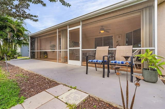 view of patio with ceiling fan and a sunroom