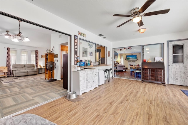 kitchen with light hardwood / wood-style flooring, ceiling fan, and decorative light fixtures