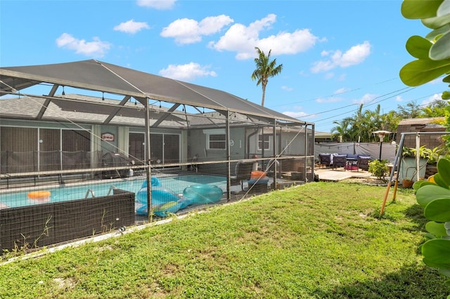 view of swimming pool featuring glass enclosure, a lawn, and a patio area