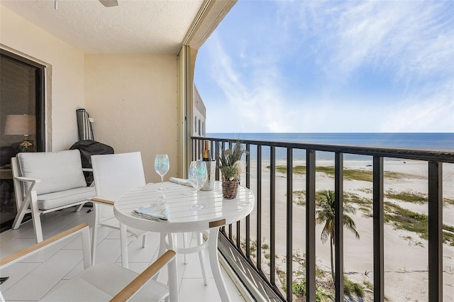 balcony with a water view and a view of the beach