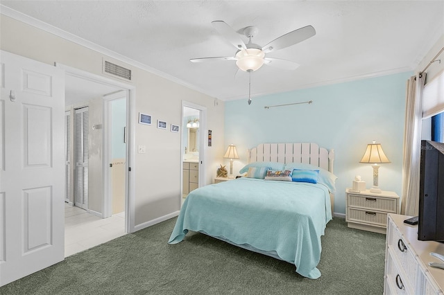 bedroom featuring crown molding, ensuite bathroom, carpet flooring, and ceiling fan