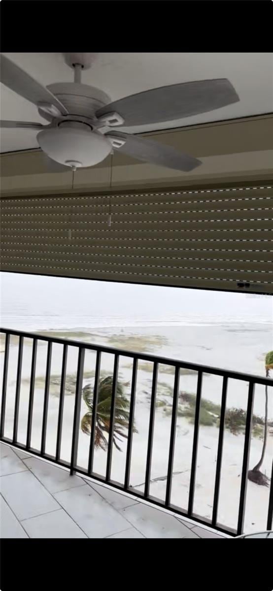 balcony with a water view and ceiling fan