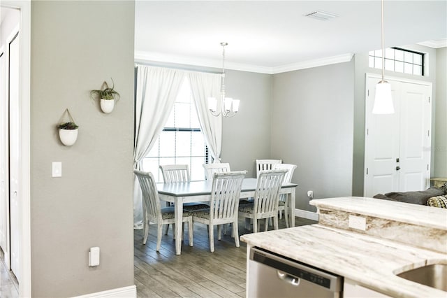 dining space featuring an inviting chandelier, light wood-type flooring, and crown molding