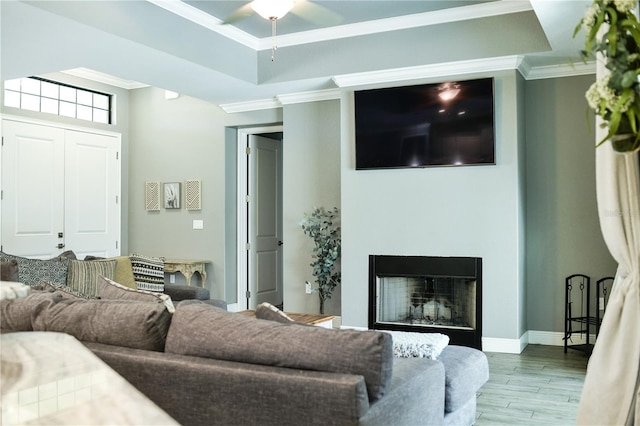 living room featuring wood-type flooring, crown molding, and ceiling fan