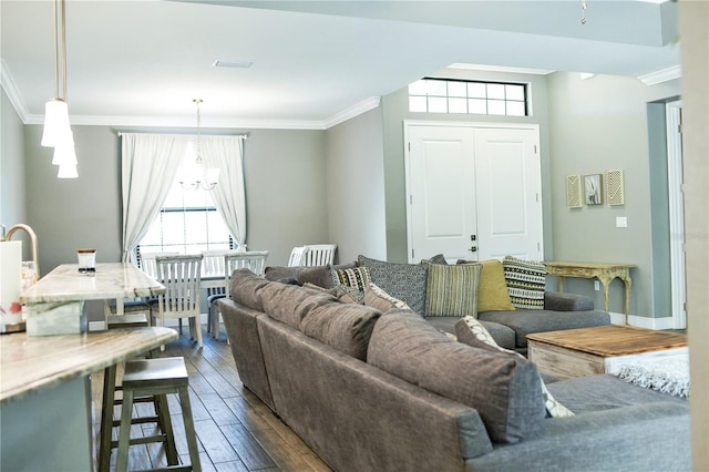 living room featuring a notable chandelier, dark hardwood / wood-style floors, and crown molding