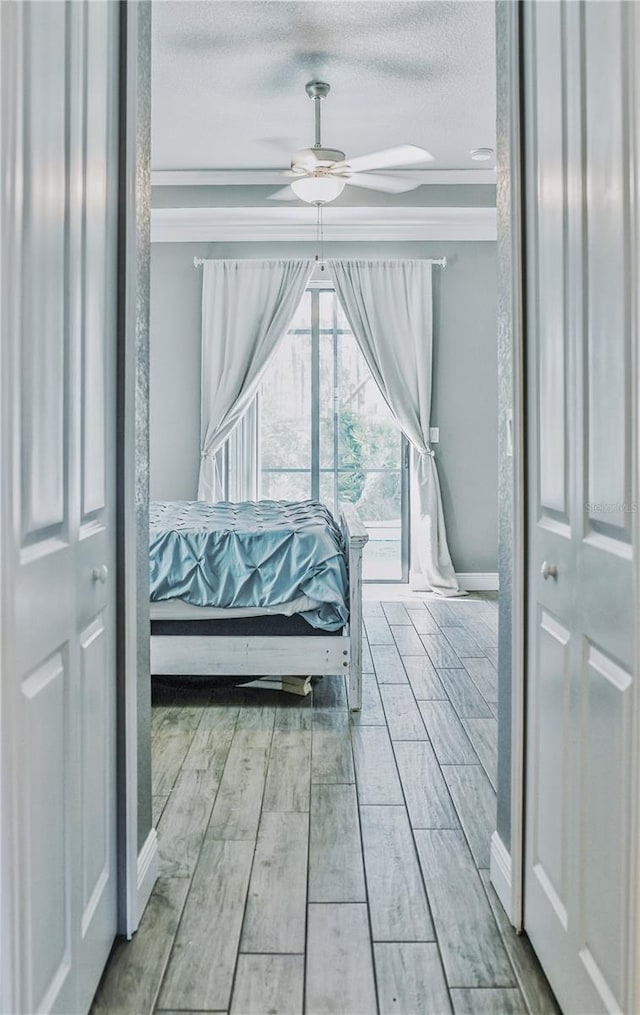 bedroom featuring light hardwood / wood-style floors, ceiling fan, and a textured ceiling