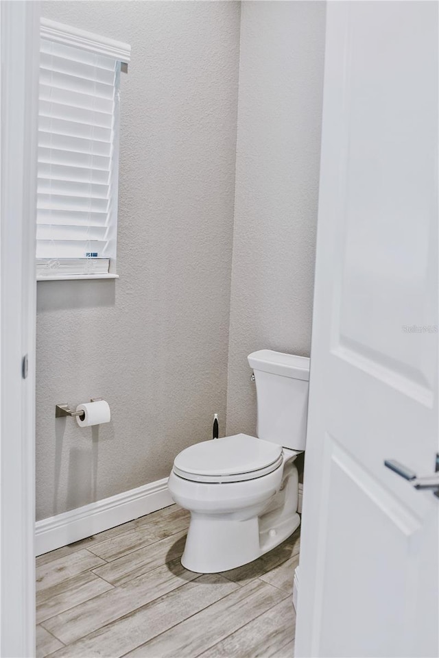 bathroom featuring hardwood / wood-style flooring and toilet