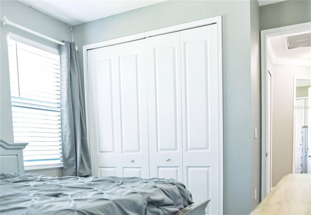 bedroom with crown molding and a closet