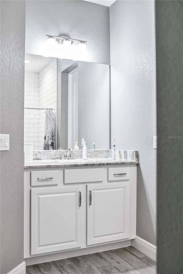 bathroom with a shower with curtain, vanity, and hardwood / wood-style floors