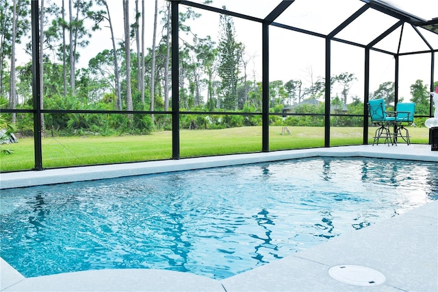 view of swimming pool with a patio, a yard, and a lanai