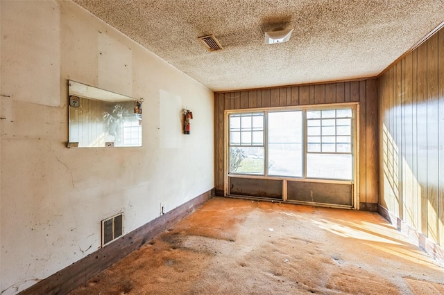 unfurnished room featuring wooden walls