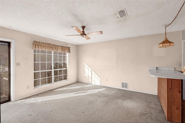 unfurnished living room featuring a textured ceiling, light colored carpet, and ceiling fan