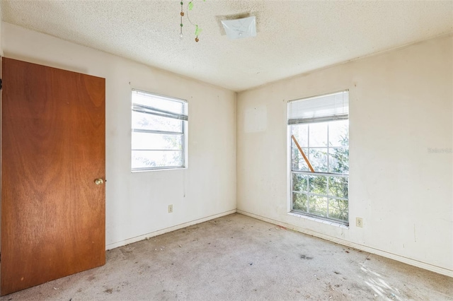 unfurnished room featuring a textured ceiling