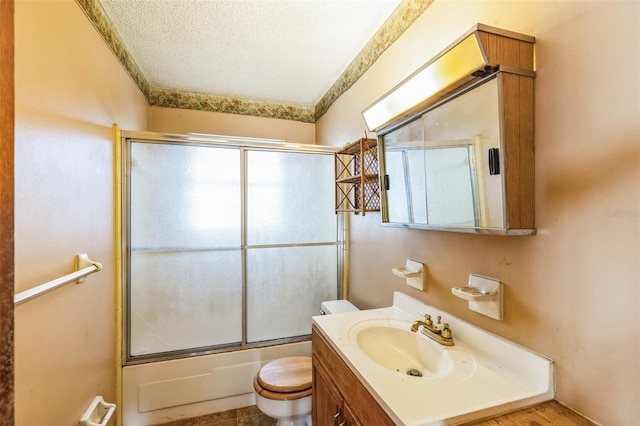 full bathroom featuring vanity, toilet, and bath / shower combo with glass door