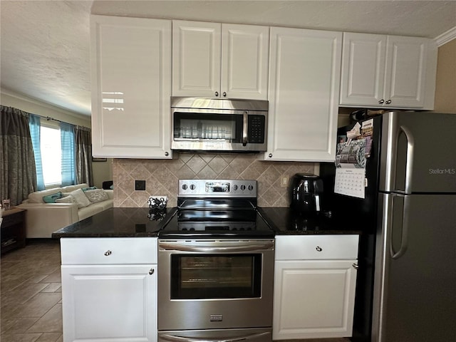 kitchen with white cabinets, decorative backsplash, tile patterned flooring, and stainless steel appliances