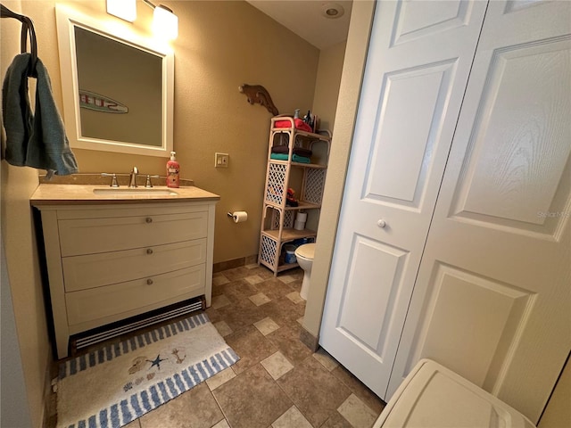 bathroom featuring vanity and toilet