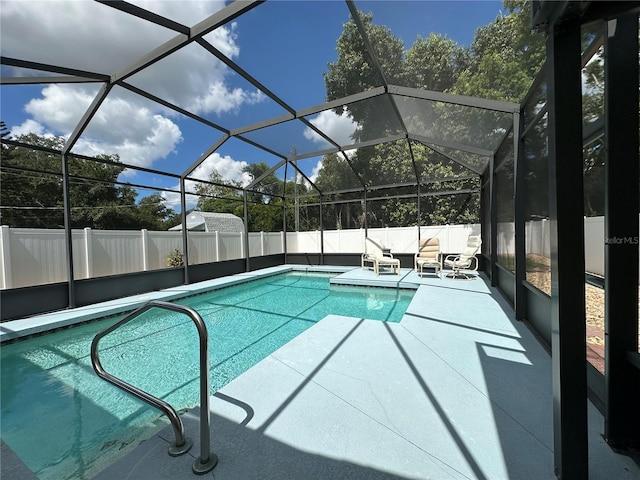 view of swimming pool featuring glass enclosure and a patio area