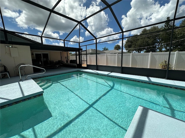 view of swimming pool with a patio area and a lanai