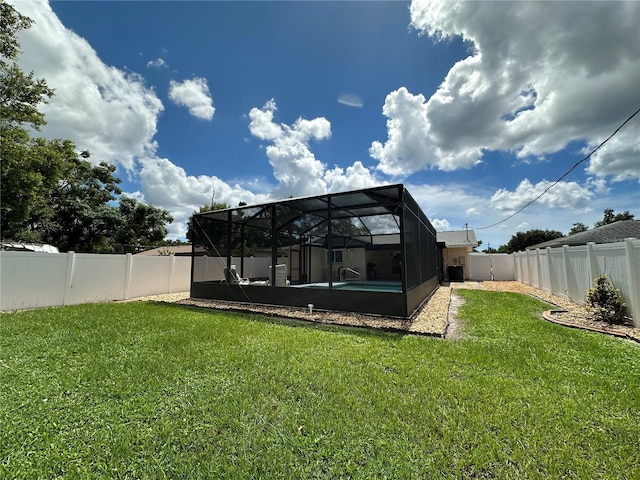 back of property with a lawn and a lanai