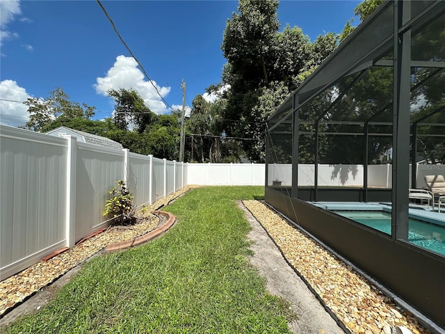 view of yard with glass enclosure and a fenced in pool