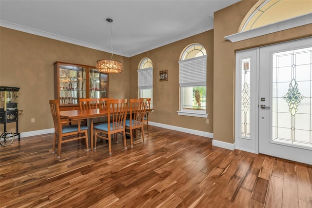 dining space with a wealth of natural light, crown molding, and dark hardwood / wood-style floors