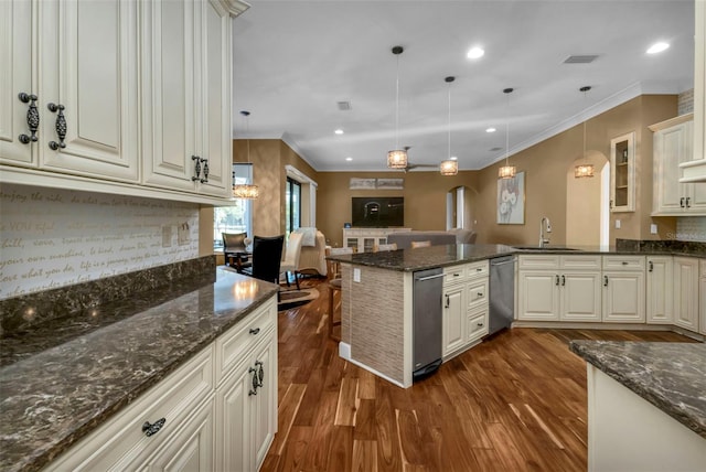 kitchen featuring dishwasher, sink, dark hardwood / wood-style floors, dark stone counters, and pendant lighting