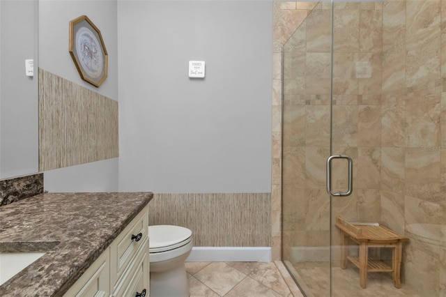 bathroom with tile patterned flooring, toilet, vanity, and walk in shower