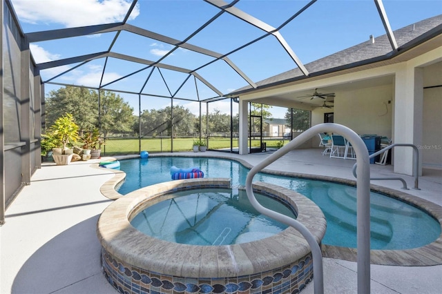 view of pool with a lanai, ceiling fan, a patio area, and an in ground hot tub