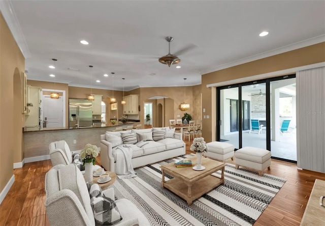 living room featuring ceiling fan, crown molding, and light hardwood / wood-style flooring