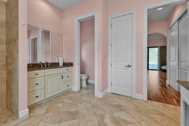 bathroom with hardwood / wood-style floors, vanity, and toilet