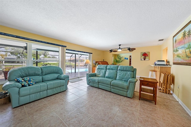 tiled living room featuring ceiling fan and a textured ceiling