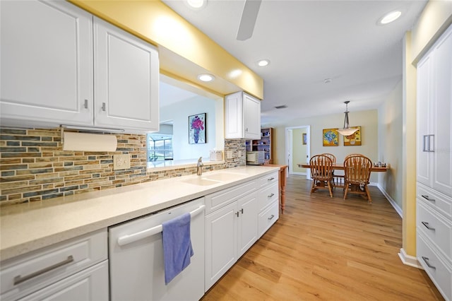 kitchen featuring white cabinetry, dishwasher, tasteful backsplash, pendant lighting, and light wood-type flooring