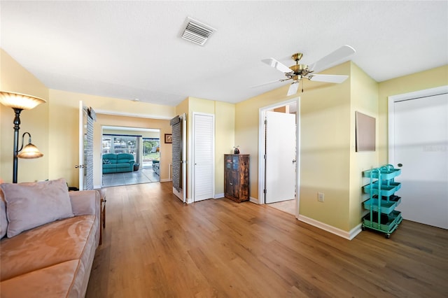 living room featuring hardwood / wood-style floors and ceiling fan