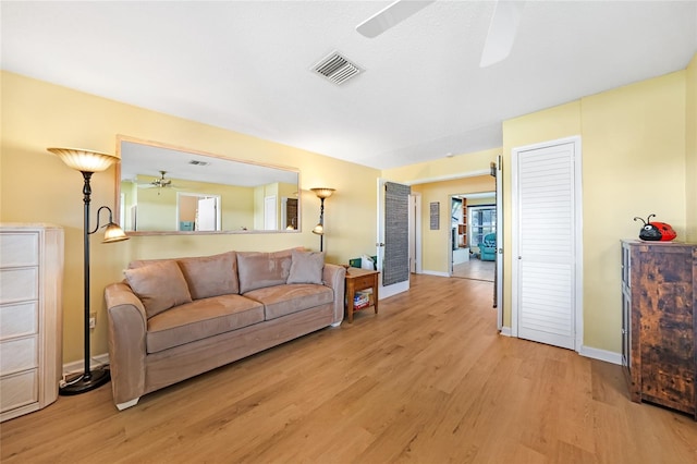 living room with light wood-type flooring and ceiling fan