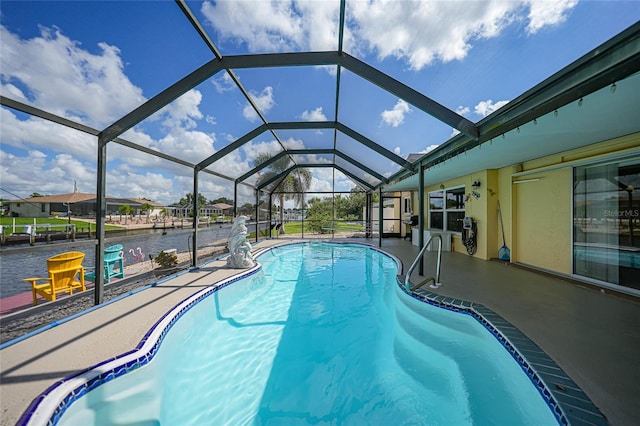 view of pool with a water view, glass enclosure, and a patio area