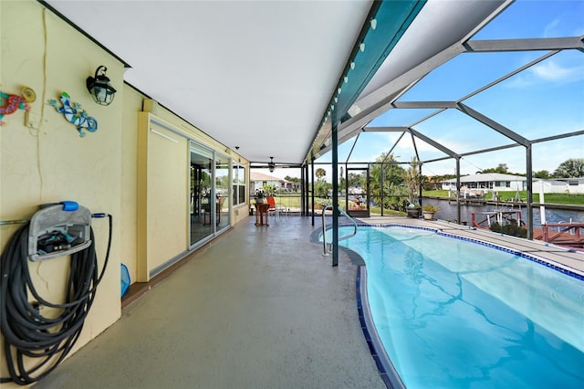 view of pool with a water view, glass enclosure, and a patio area