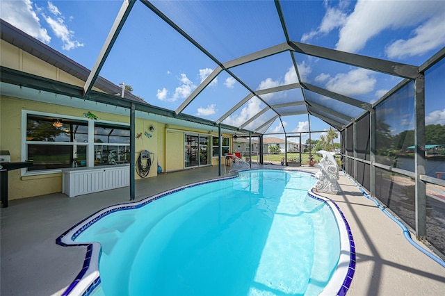 view of swimming pool with a patio area and a lanai