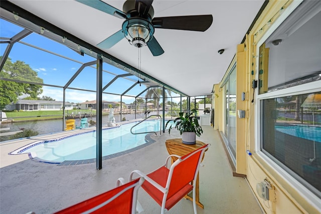 view of pool with a water view, ceiling fan, a patio, and a lanai